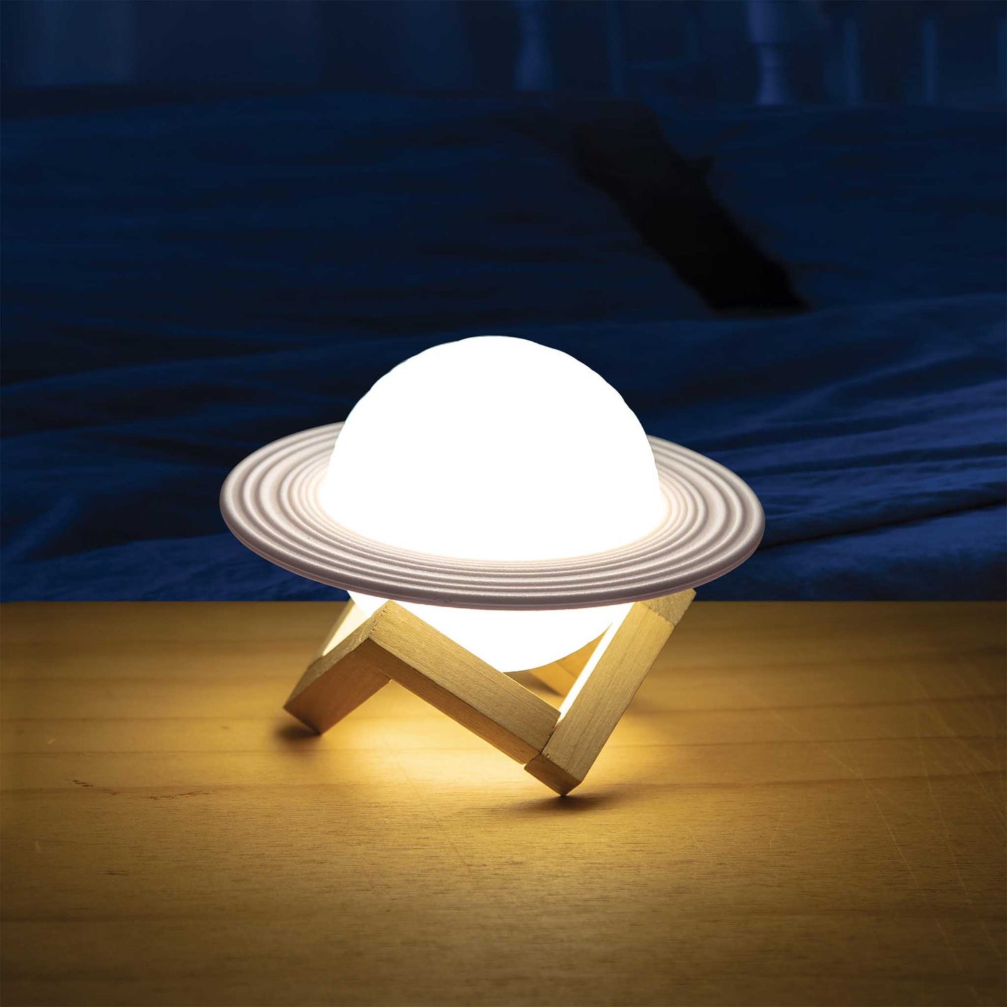 Light bulb on a wooden stand with a dark blue fabric background