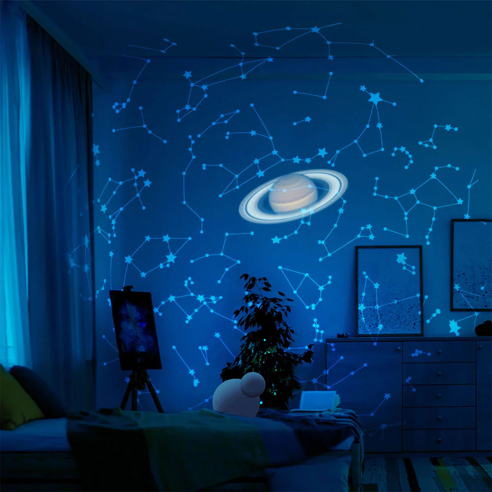 Room with star and planet projections on the wall, creating a cosmic ambiance.