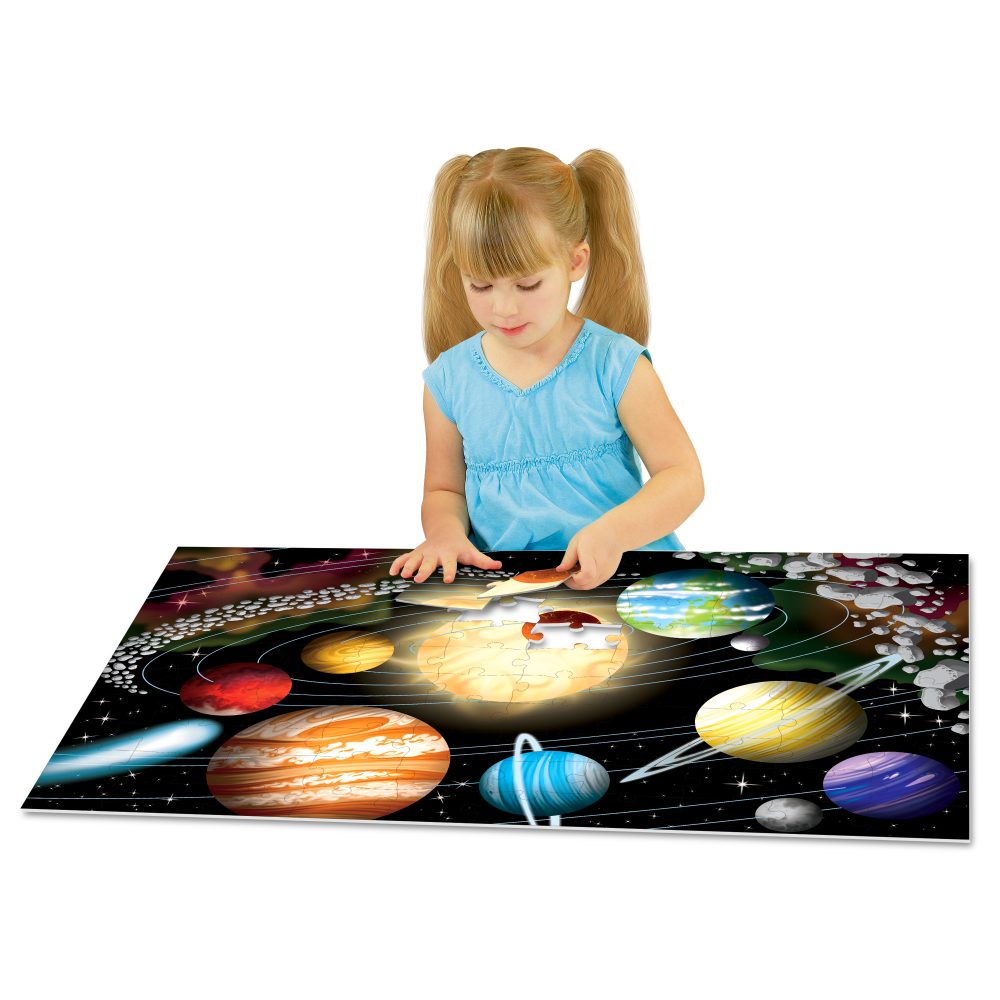 Child playing with a solar system-themed mat on a white background