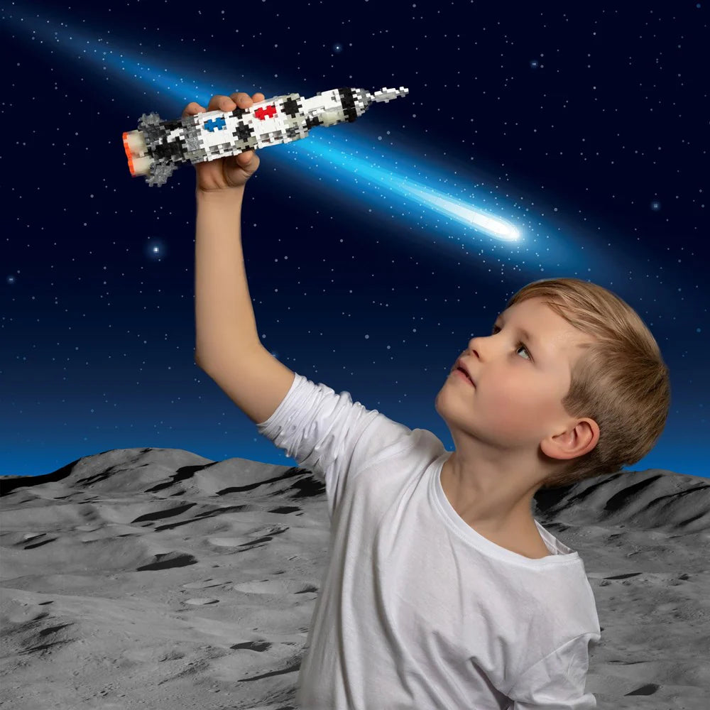 Child holding a toy rocket on a moon surface with a starry sky background