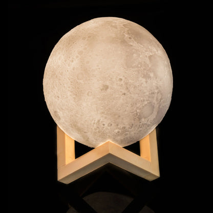 Moon-shaped lamp with wooden base on a black background