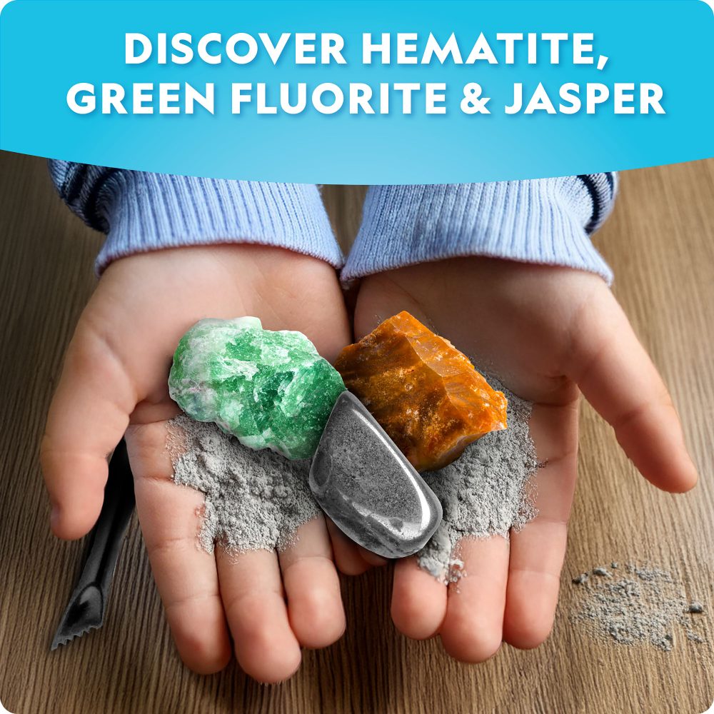 Hands holding green fluorite, orange jasper, and gray hematite crystals on a wooden surface.