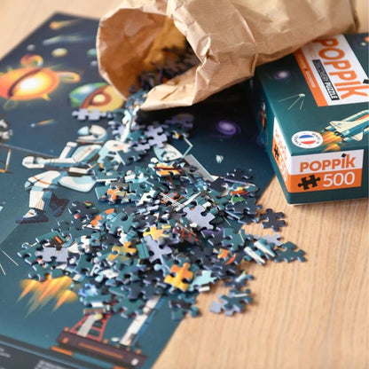 Puzzle with pieces scattered on a table, next to a PopPik box.
