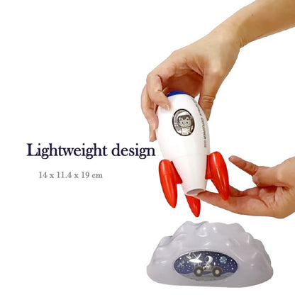Toy rocket being held by a hand with a cloud-shaped base on a white background