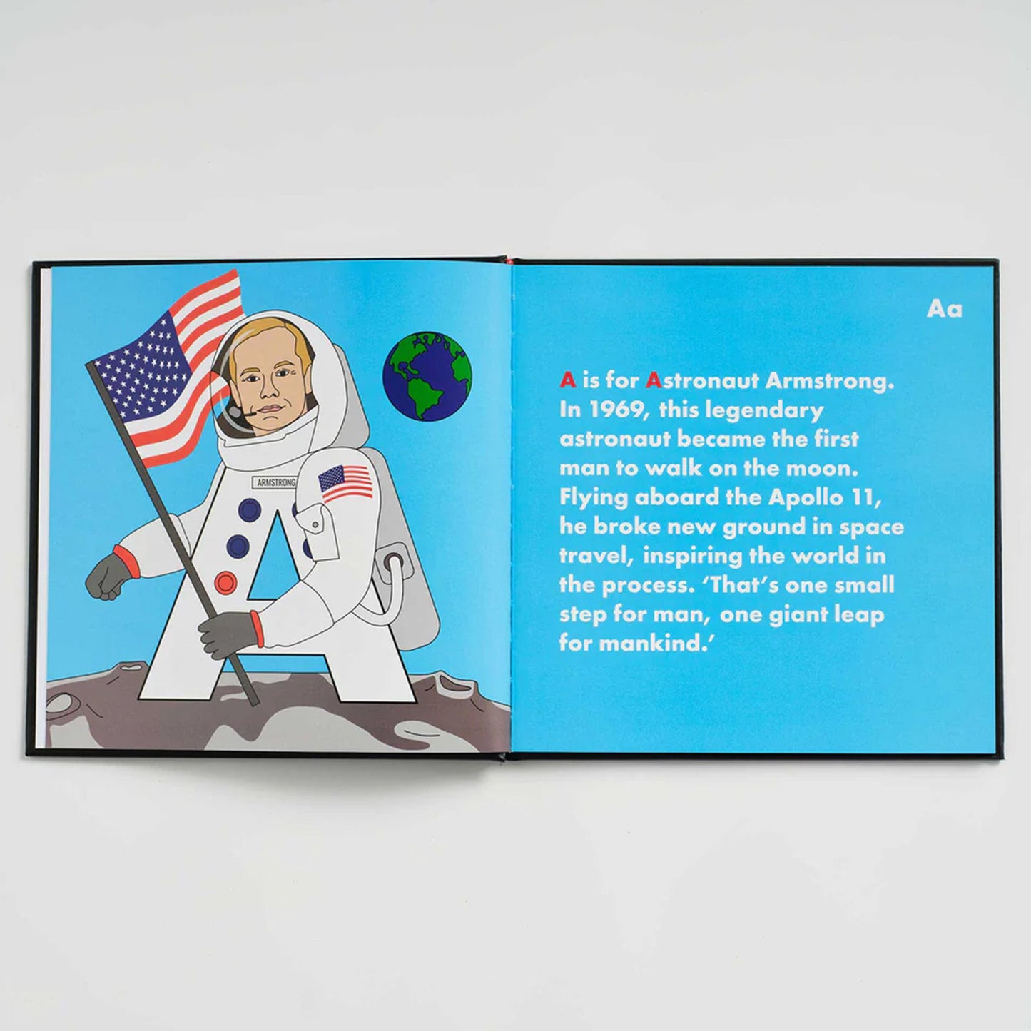Book open to a page about Astronaut Armstrong with an illustration of an astronaut holding an American flag.